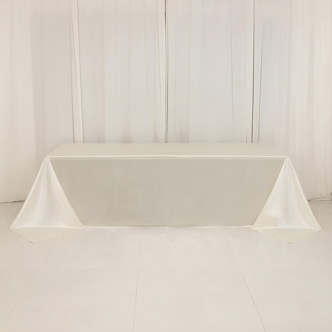 Elegant white table with draped satin cloth, perfect for events or displays.