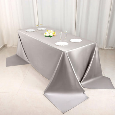 Elegant silver tablecloth draped over a table with decorative elements.
