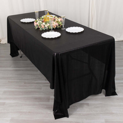 Black tablecloth draped over a table set for an elegant dining experience.