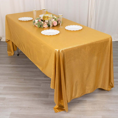 Gold tablecloth draped over a table, styled for an elegant dining setup.