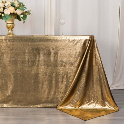 Gold shimmer tablecloth draping elegantly over a table with floral centerpiece.
