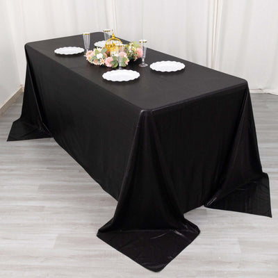 Elegant black tablecloth draping over a dining table set for a formal occasion.