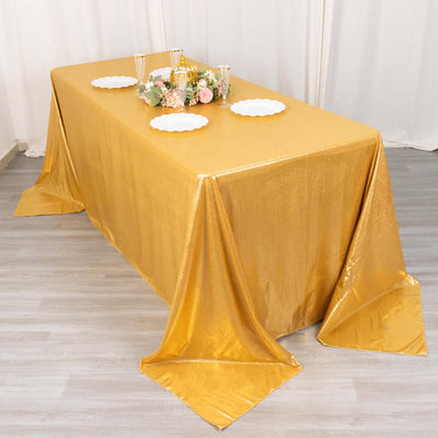 Gold shimmer tablecloth draped elegantly over a table with floral centerpiece.