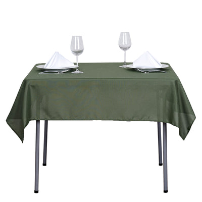 Green tablecloth set with elegant tableware and wine glasses