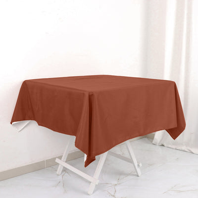 Brown tablecloth draped over a folding table in a bright, minimalistic setting.