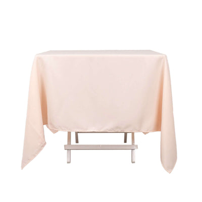 Peach tablecloth draped over a white table.