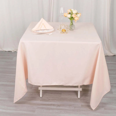 Elegant peach tablecloth draped on a table with decor and flowers.