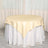 Round table with a cream satin tablecloth and white skirt.