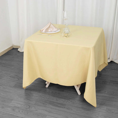 Yellow tablecloth draped over a table with glassware and decor.