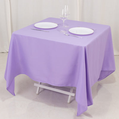 Purple tablecloth draped over a table set with plates and glassware.