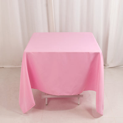 Pink tablecloth draped over a table in a studio setting.