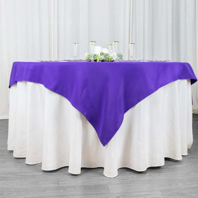 Purple tablecloth draped over a white table for elegant dining setup.