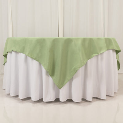 Green tablecloth draped over a white table with a scalloped edge.