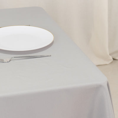 White plate on a gray tablecloth with a fork beside it.