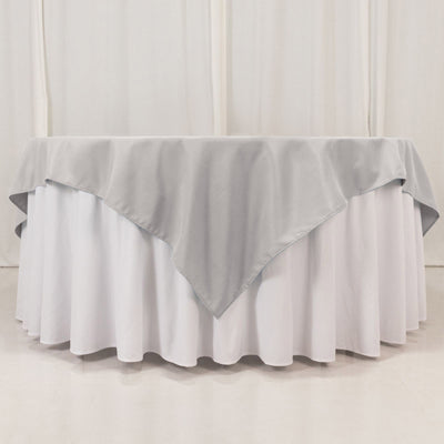 Gray tablecloth with white underneath, elegantly draped.
