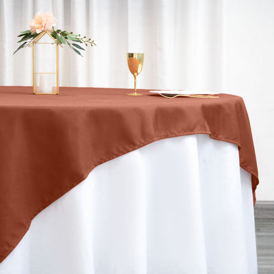 Brown tablecloth draped over a white table with decorative elements.