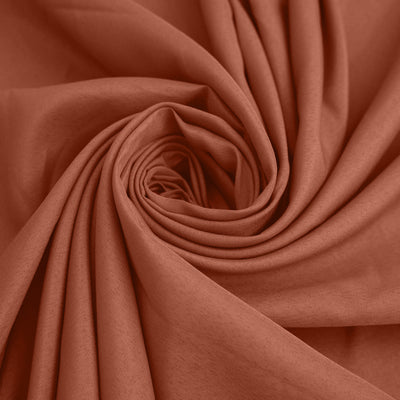 Rust-colored fabric in a swirling pattern, showcasing its texture and softness. #whtbkgd