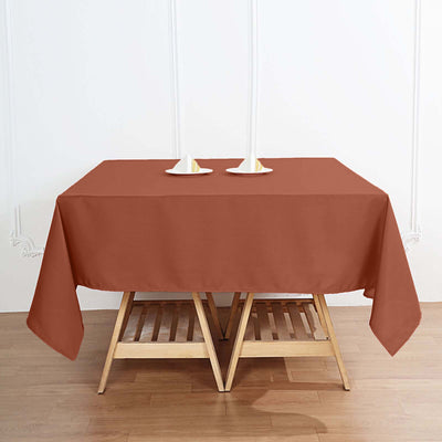 Rust-colored tablecloth on a wooden table with candle holders