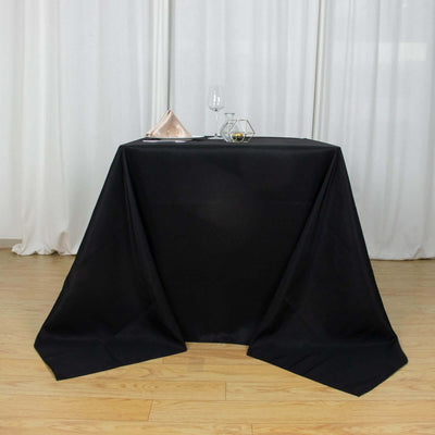 Black tablecloth draped over a table with decorative items on top.