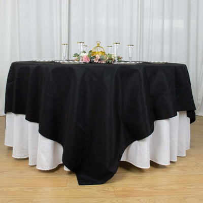 Elegant black tablecloth draping a round table with floral centerpiece.