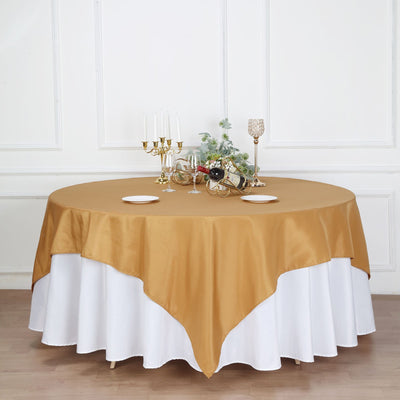 Gold and white round tablecloth on a dining table with decor.