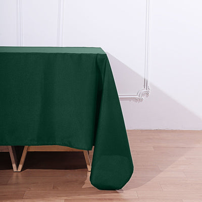 Green tablecloth draped over a wooden table in a bright setting.