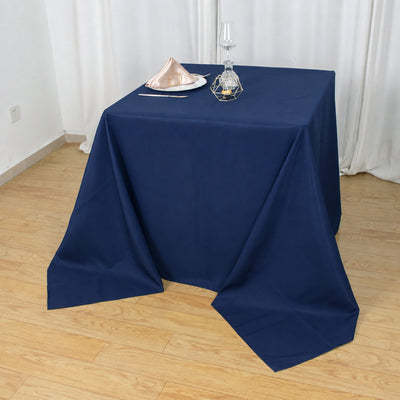 Navy blue tablecloth with elegant table setting in a bright dining room