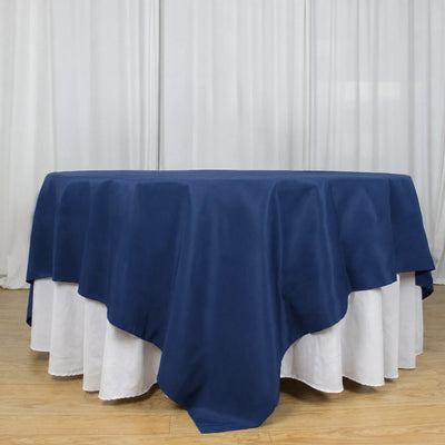 Round table with navy blue overlay and white floor-length tablecloth
