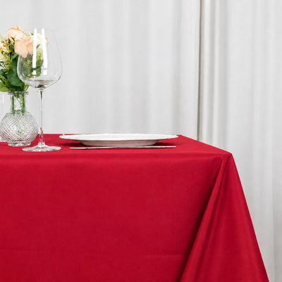 Red tablecloth elegant dining table with glassware and roses