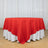 Red sheer round tablecloth over white table skirt in elegant event setup