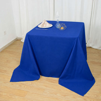Blue tablecloth dining table with decorative plate, glassware, and centerpiece