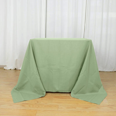 Green tablecloth draped over a table on a wooden floor.