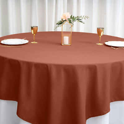 Brown tablecloth draped over a round table set for an elegant dining experience.