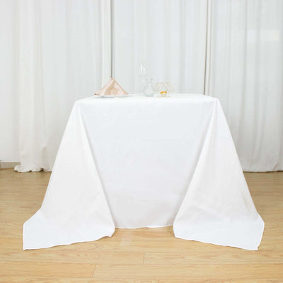 White tablecloth draped elegantly on a wooden table in a bright setting.