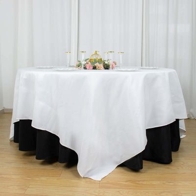 Elegant white tablecloth draped over a round table with floral centerpiece.