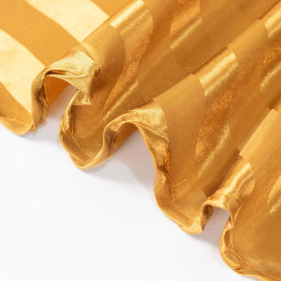 Gold satin fabric with elegant wavy texture and stripes.