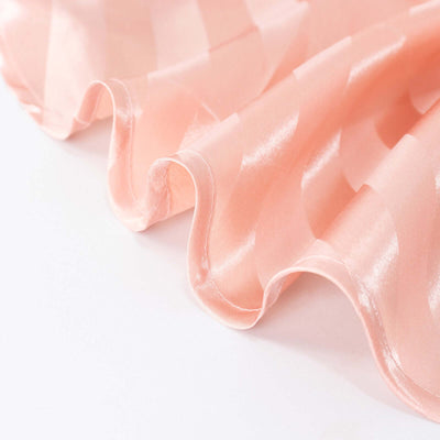 Pink satin fabric with a wavy texture.