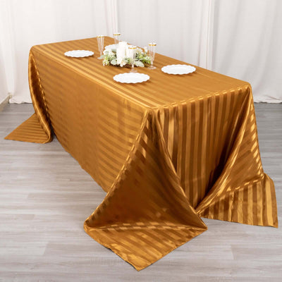 Gold striped tablecloth draped over a table with decorative items.