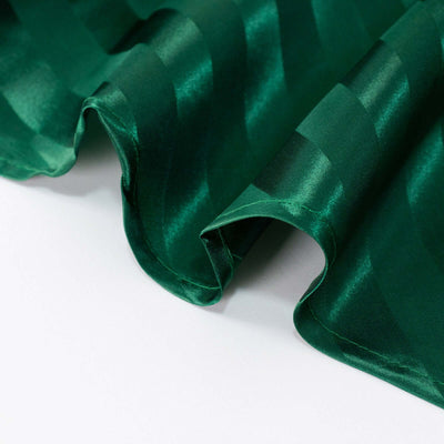 Green satin fabric with a wavy texture, showcasing its sheen and softness.