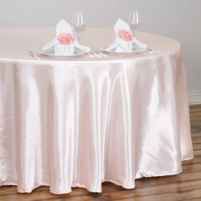 Pink satin tablecloth draped elegantly over a round table set for dining.