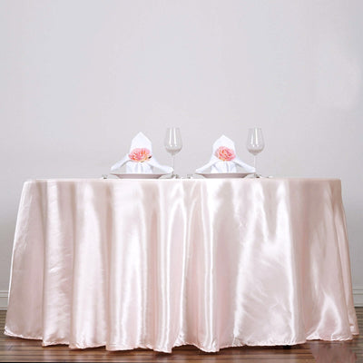 Elegant satin tablecloth with decorative napkins and glassware for a romantic setting.