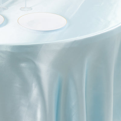 Light blue tablecloth draped elegantly over a table with white plates.