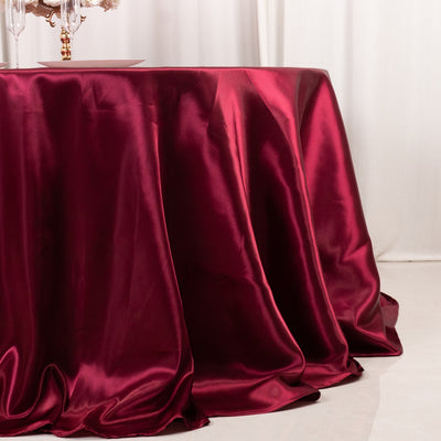 Burgundy satin tablecloth draping elegantly over a table.