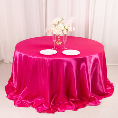 Pink satin tablecloth with elegant floral centerpiece and tableware.