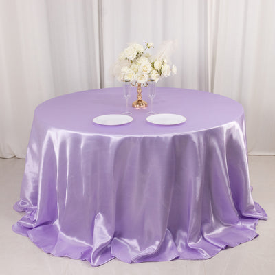 Purple satin tablecloth with white plates and floral centerpiece.