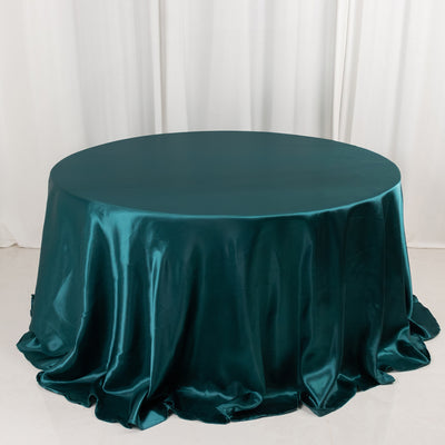 Teal satin tablecloth draped elegantly over a round table.