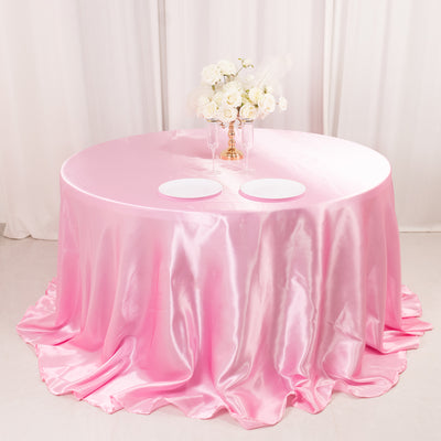 Pink satin tablecloth with elegant white floral centerpiece.