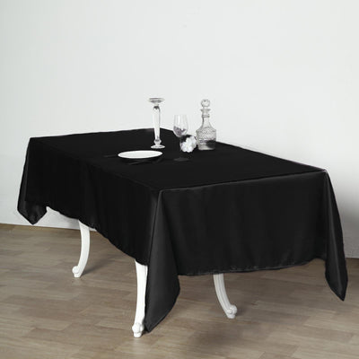 Elegant black tablecloth draped over a table setting with glassware.