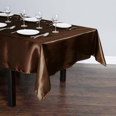 Brown satin tablecloth draped over a dining table set with plates and glasses.