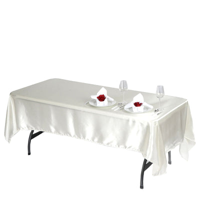 Elegant rectangular table with a cream satin tablecloth set for dining.